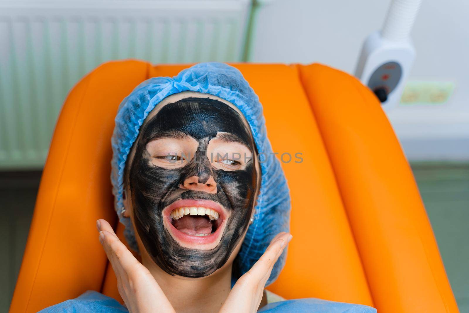 Black mask on girl face for carbon peeling. Dermatology and cosmetology. Using surgical laser