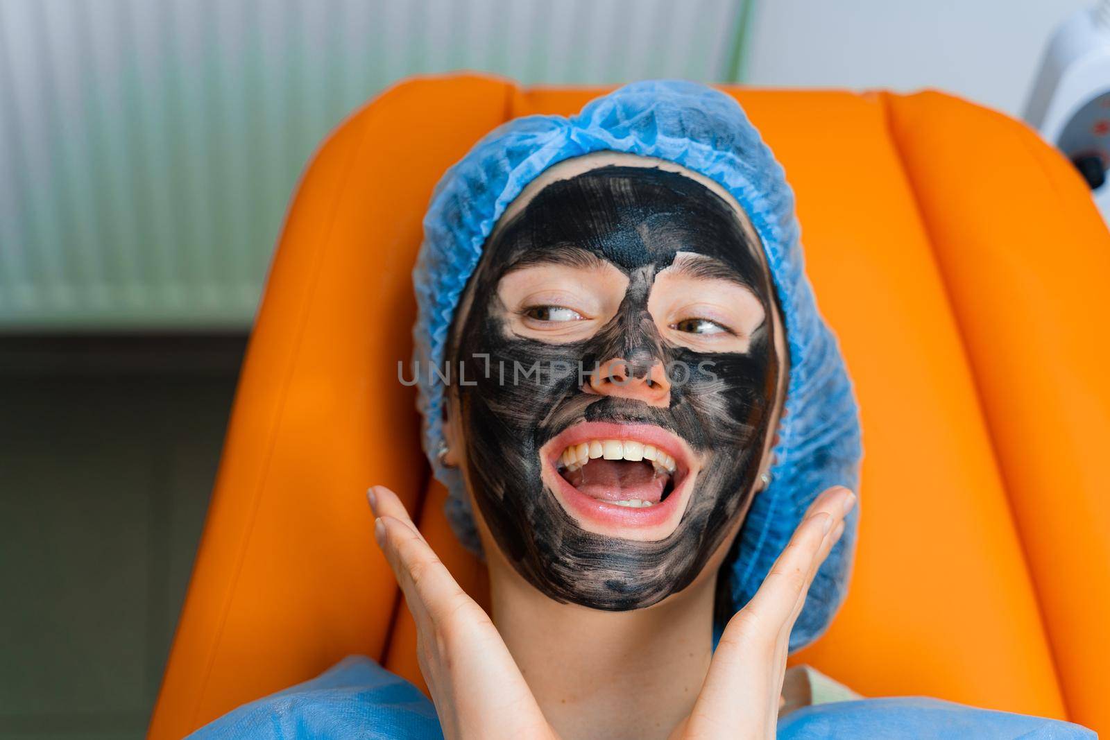 Black mask on girl face for carbon peeling. Dermatology and cosmetology. Using surgical laser