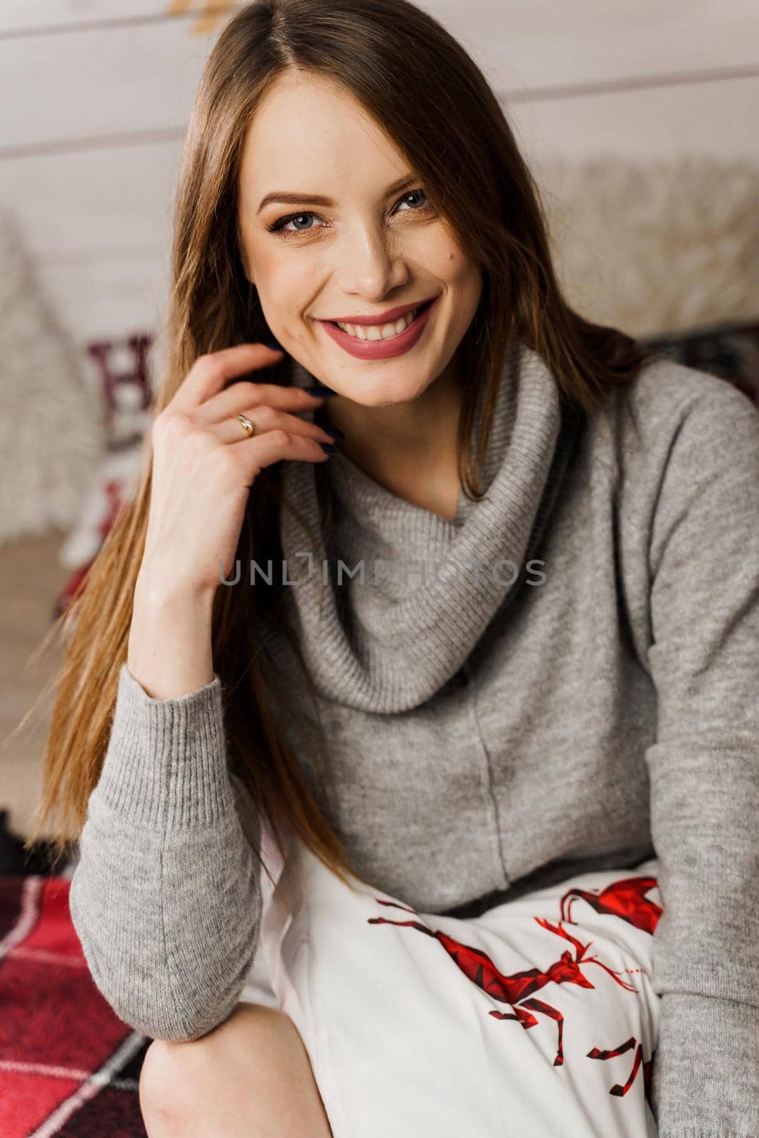 Young woman smiling in new year decoration. Christmas celebration. Attractive girl weared in warm woolen sweater and socks by Rabizo