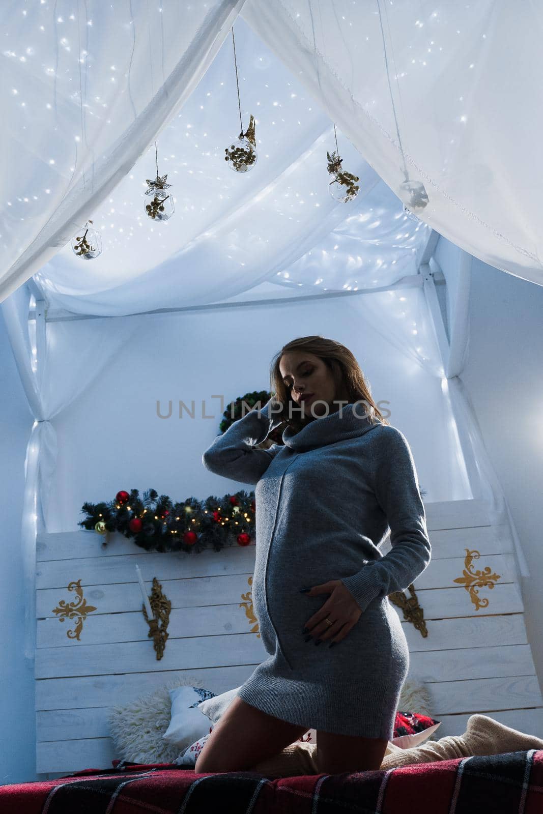 Pregnant woman in new year decoration. Pregnancy. Waiting for baby on 1 january. Maternity. Waiting for a baby.