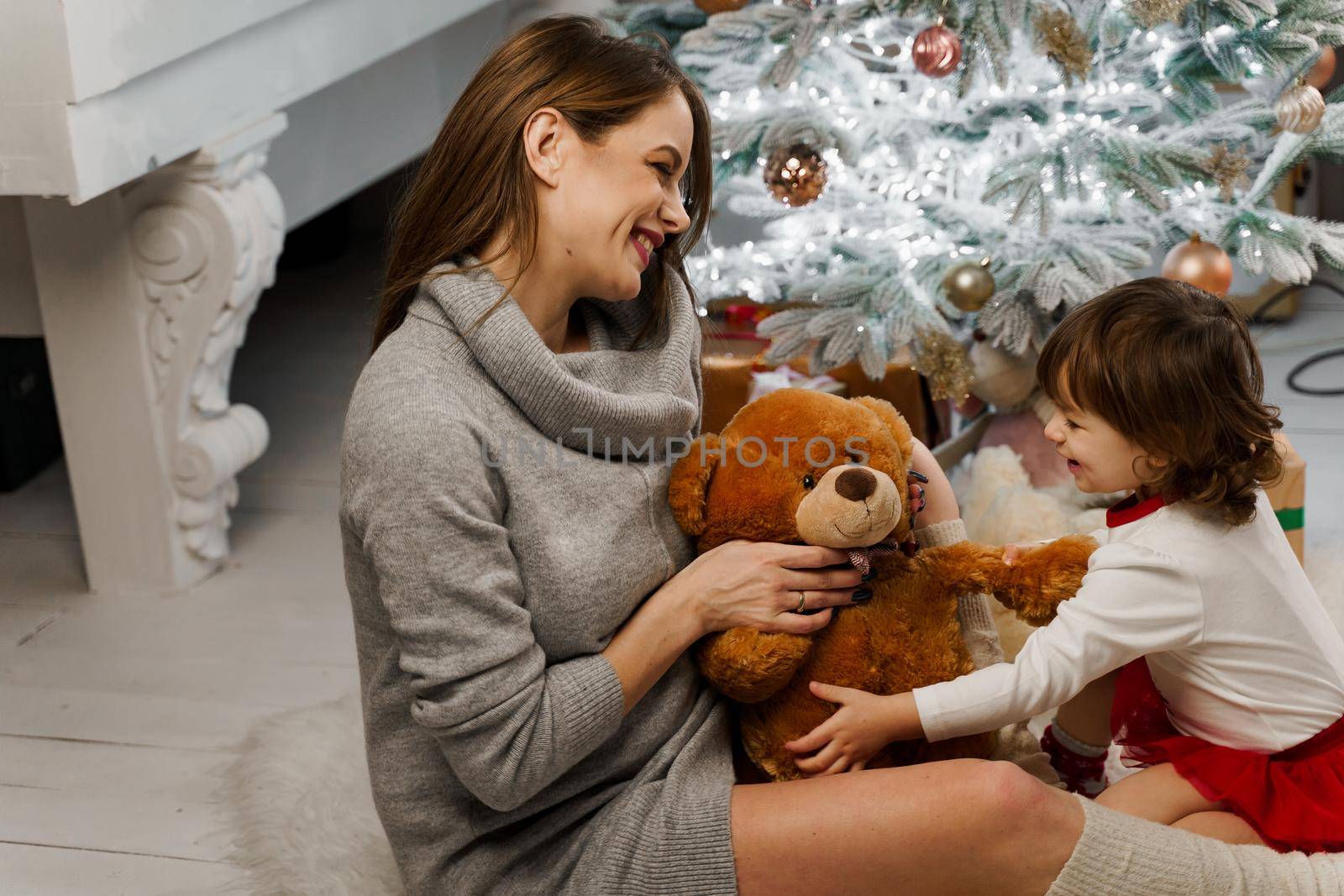 Mother and daughter preparing for christmas celebration. Having fun with family near new year tree. Pregnant woman with daughter. by Rabizo