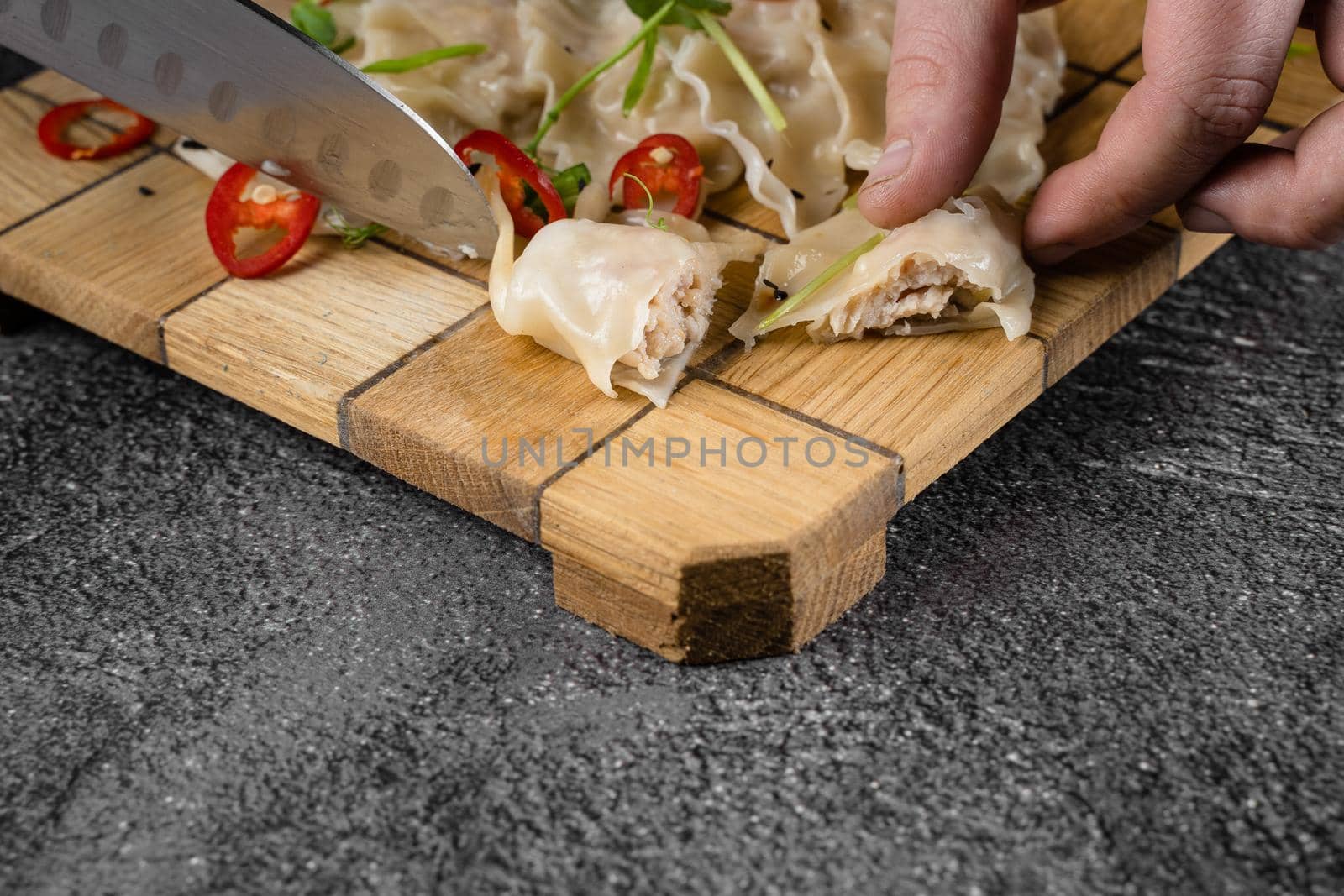 Jiaozi chinese dumplings named gyoza on wooden plate. Asian traditional fast food. Dough dish stuffed with meat and vegetables, less often only meat. by Rabizo
