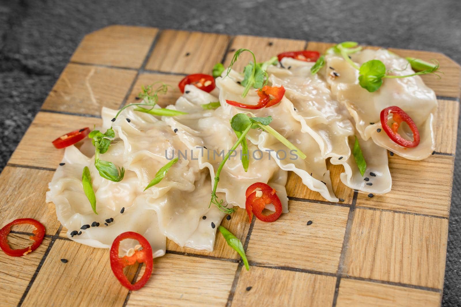 Jiaozi chinese dumplings named gyoza on wooden plate. Asian traditional fast food. Dough dish stuffed with meat and vegetables, less often only meat. by Rabizo