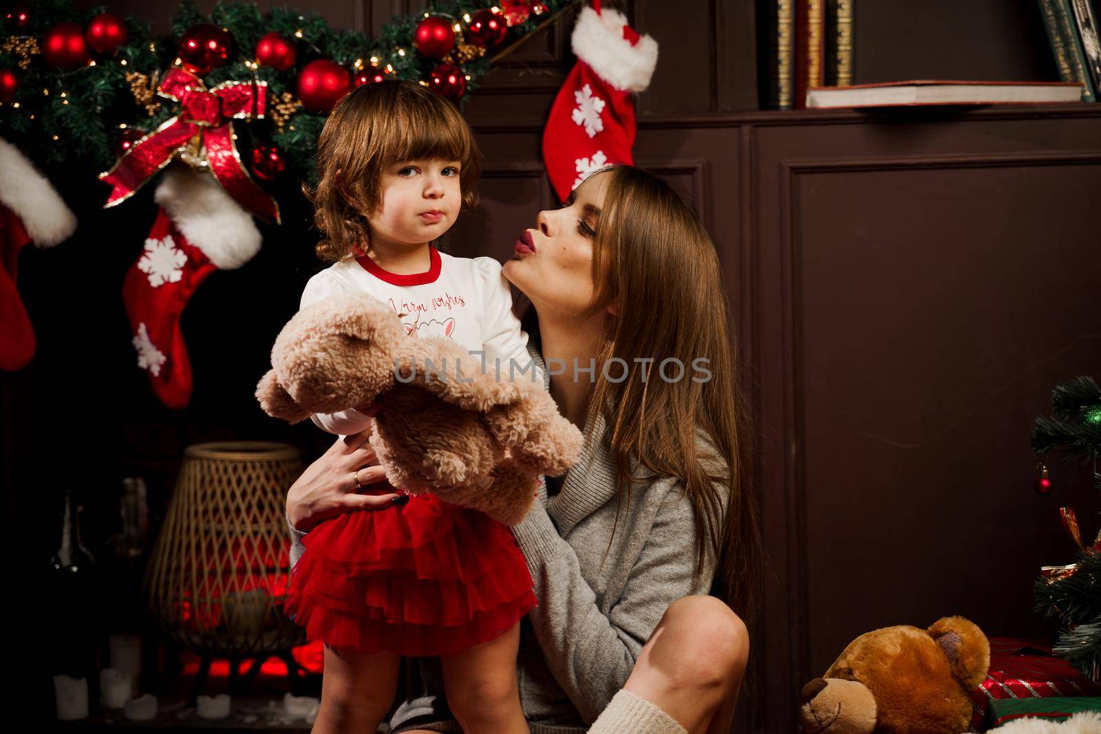 Mother and daughter preparing for christmas celebration. Having fun with family near new year tree. Pregnant woman with daughter