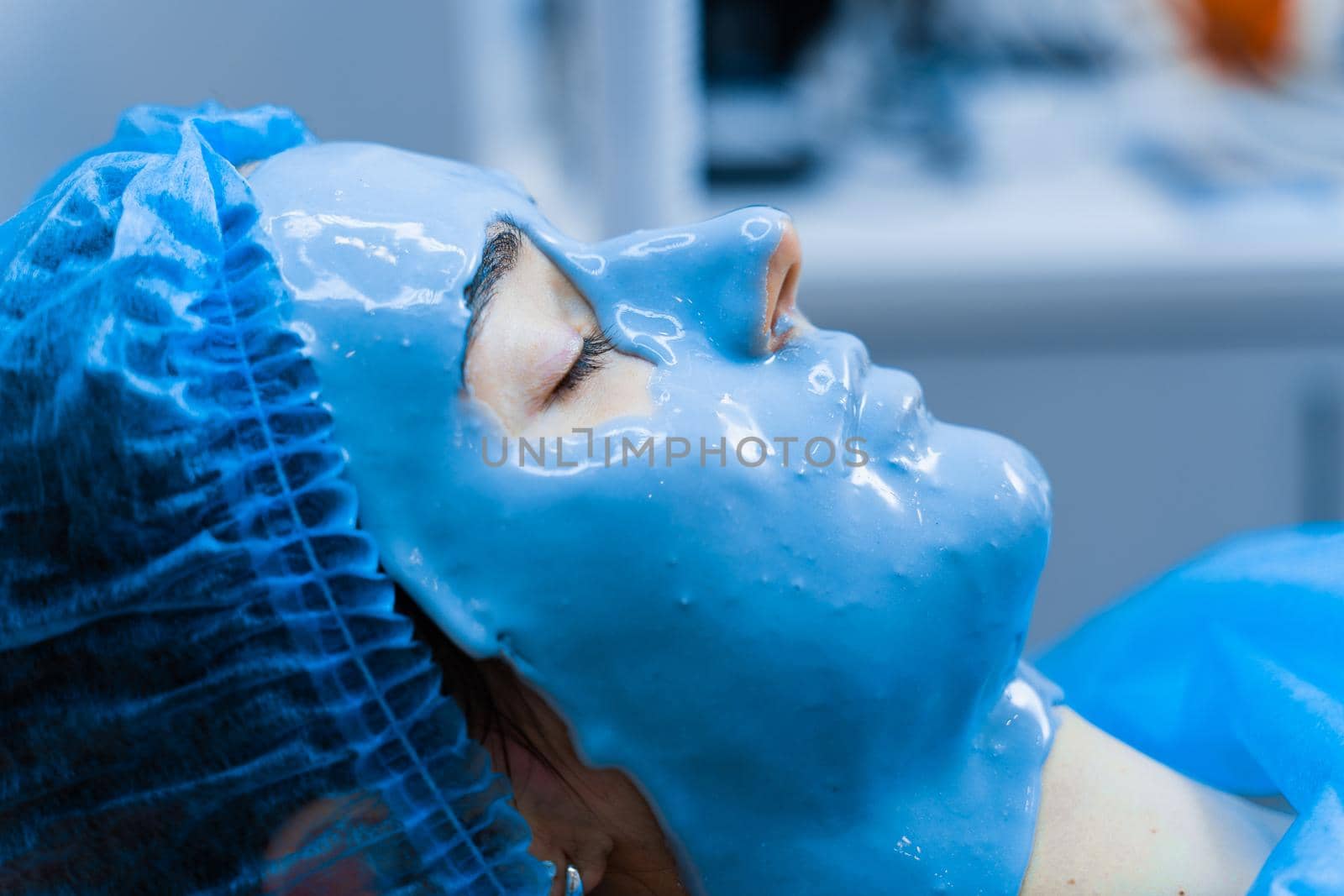 Alginate moisturizing mask for face and skin of young girl. Spa procedure for rejuvenation. beautician smears blue mask. Dermatology in medical clinic, by Rabizo