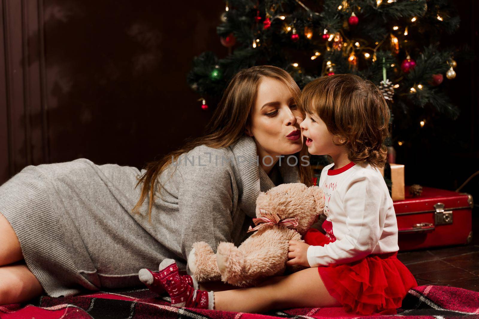 Mother and daughter preparing for christmas celebration. Having fun with family near new year tree. Pregnant woman with daughter