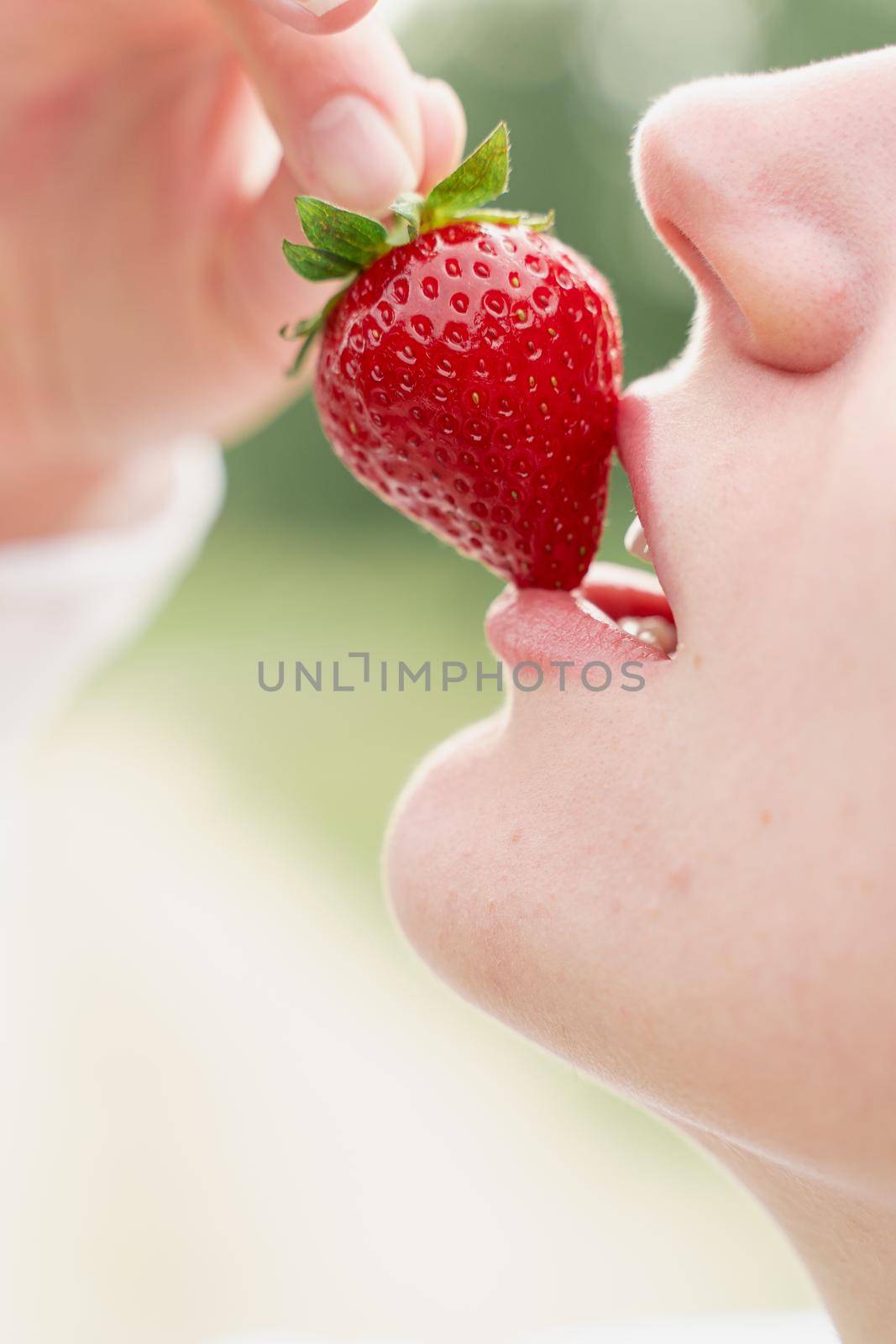 Woman enjoy strawberry close-up. Kisses and tastes strawberry. Seasonal berry by Rabizo