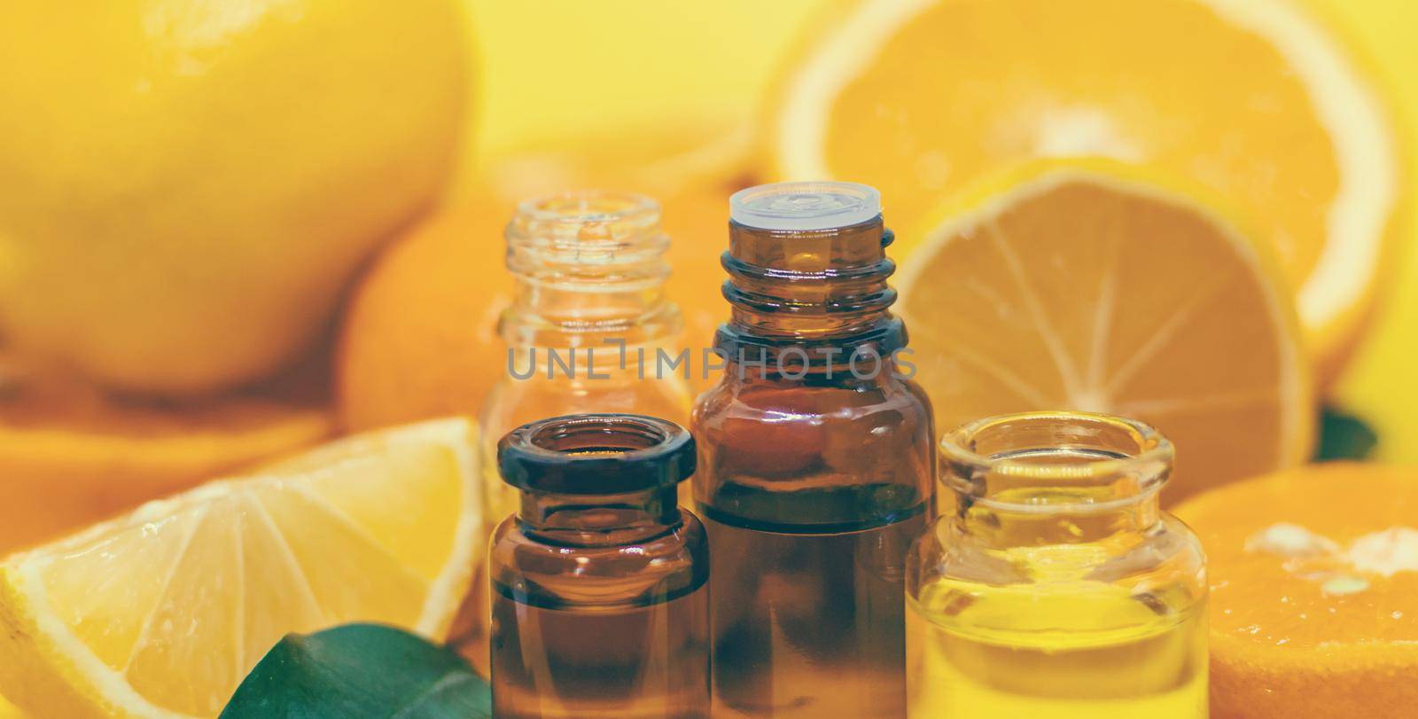 orange essential oil on a yellow background. Selective focus. by mila1784