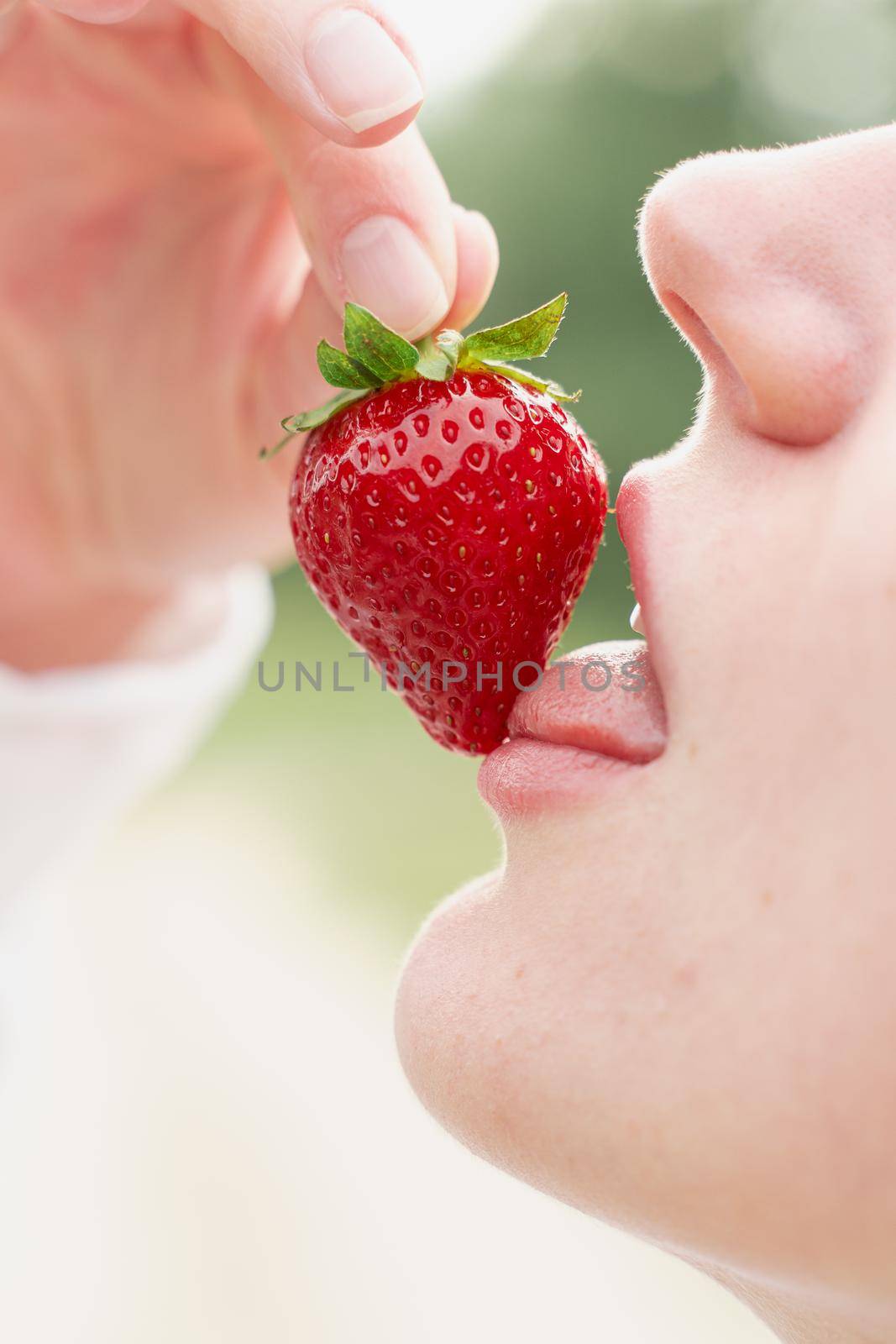 Woman enjoy strawberry close-up. Kisses and tastes strawberry. Seasonal berry.
