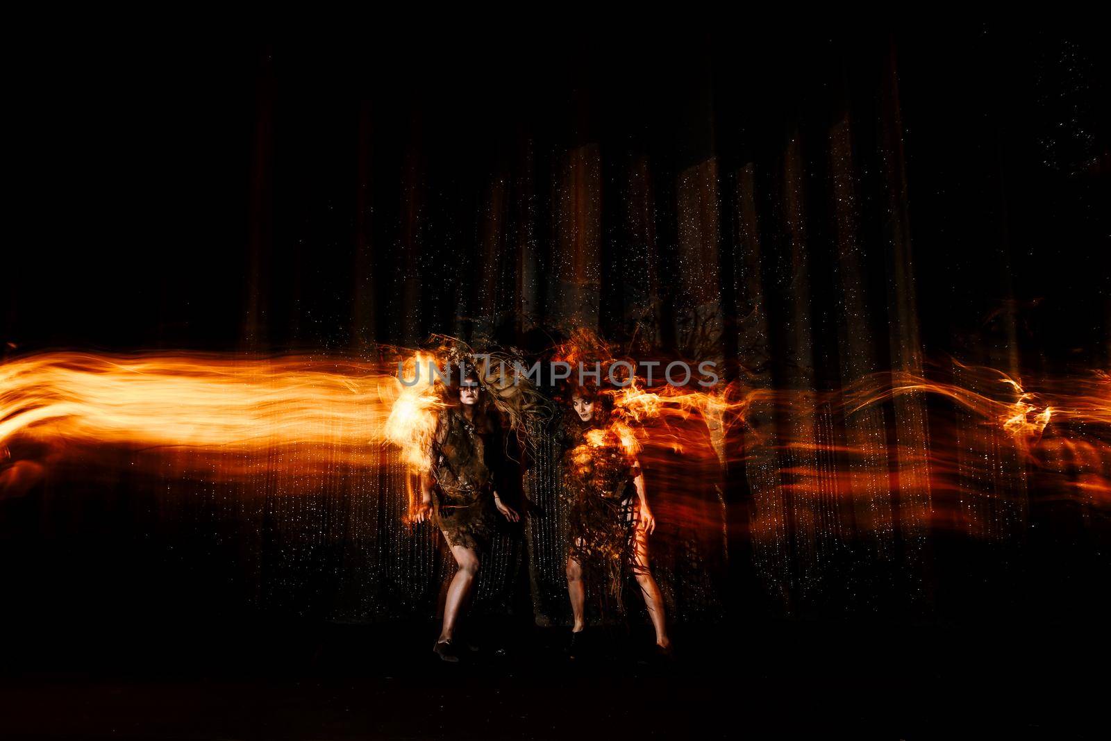 Ghost girls, spirits of the theater, accompanied by a trail of fire, on the stage of the theater. by deandy