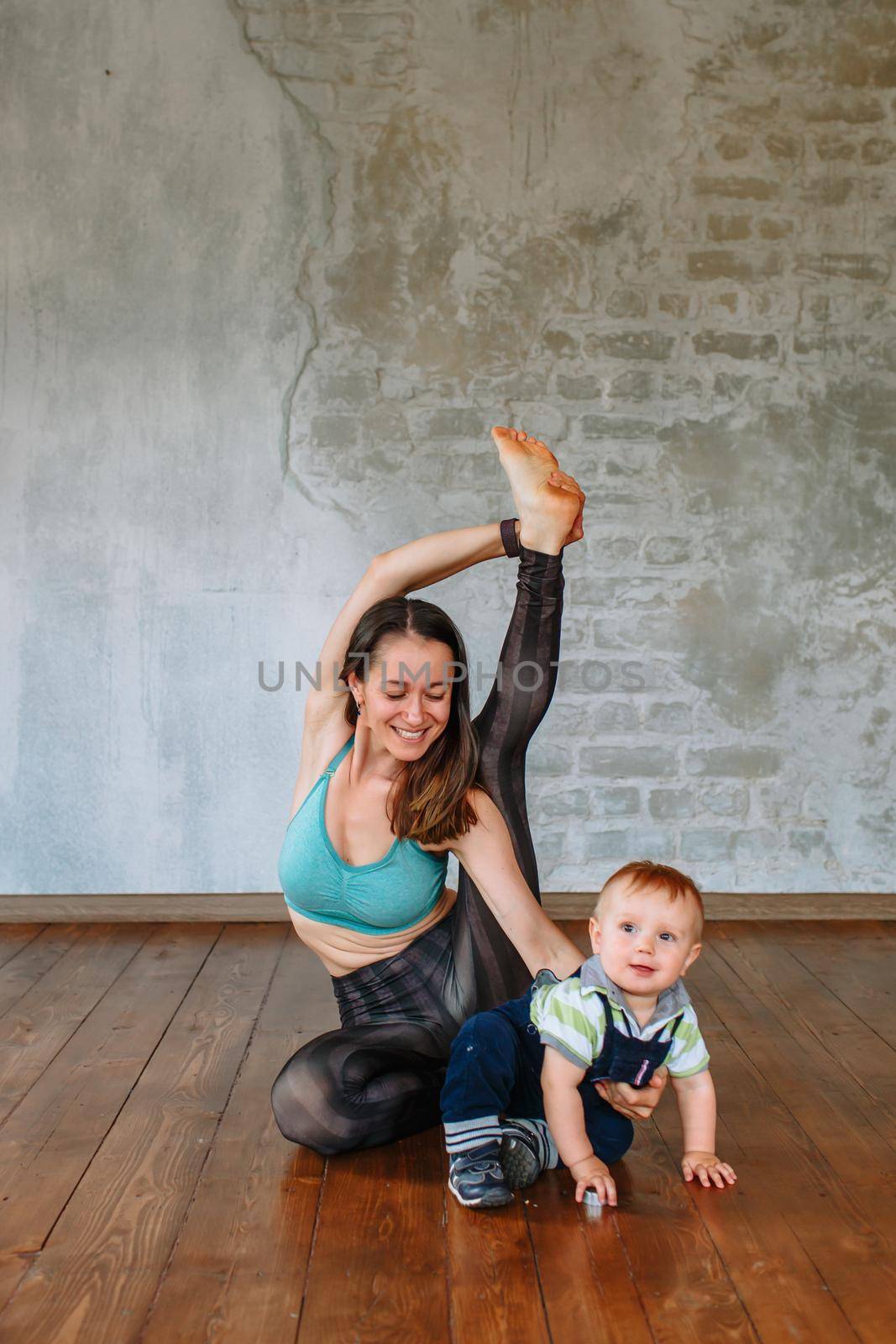 A yoga girl performs an asana exercise, next to her li by deandy