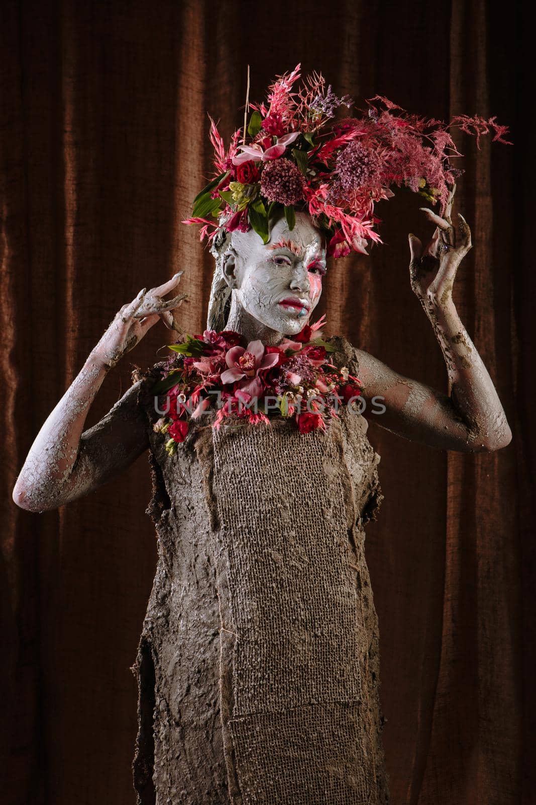 A girl smeared with clay in a cemented dress. The model has a headdress made of flowers. by deandy