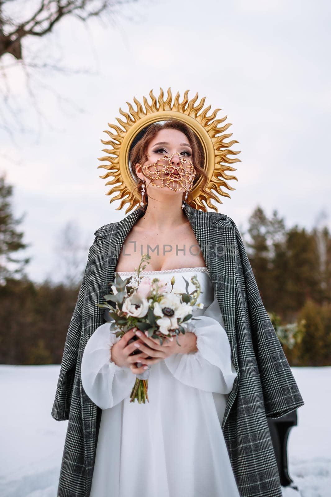 The bride is standing in a snow-covered forest. The bride in a fabulous protective mask. Above the bride is a halo by deandy