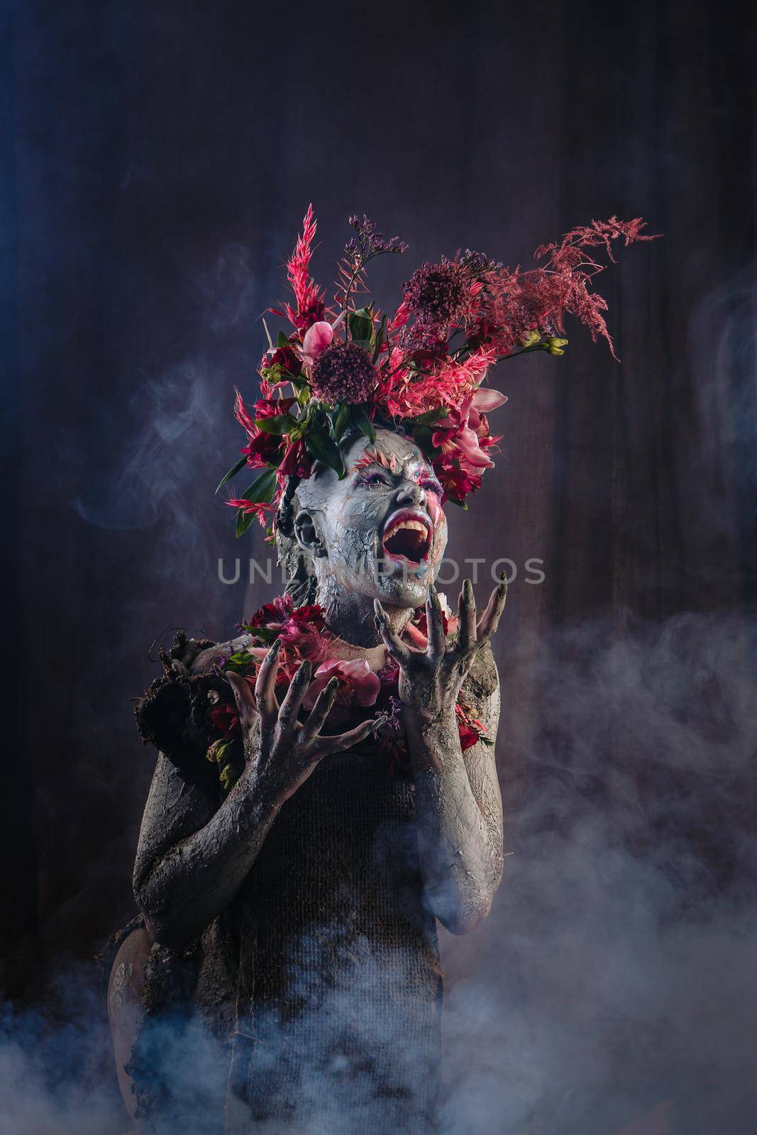 A screaming girl smeared with clay in a cemented dress. The model has a headdress made of flowers. Smoke from behind. by deandy