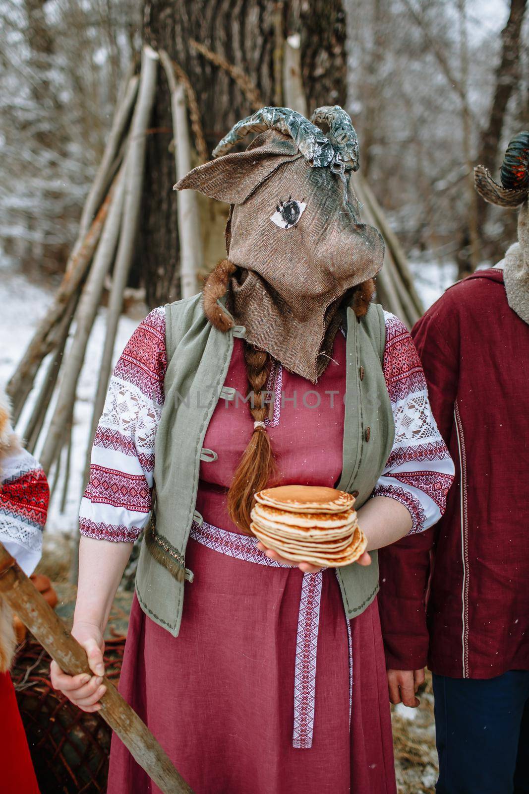 A man in a national costume with the head of an animal celebrates the arrival of the pagan holiday Maslenitsa.