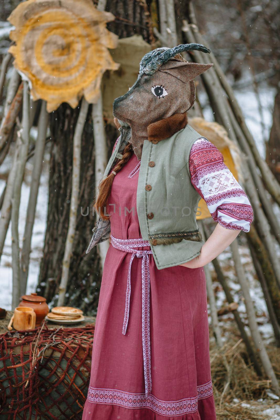 A man in a national costume with the head of an animal celebrates the arrival of the pagan holiday Maslenitsa.