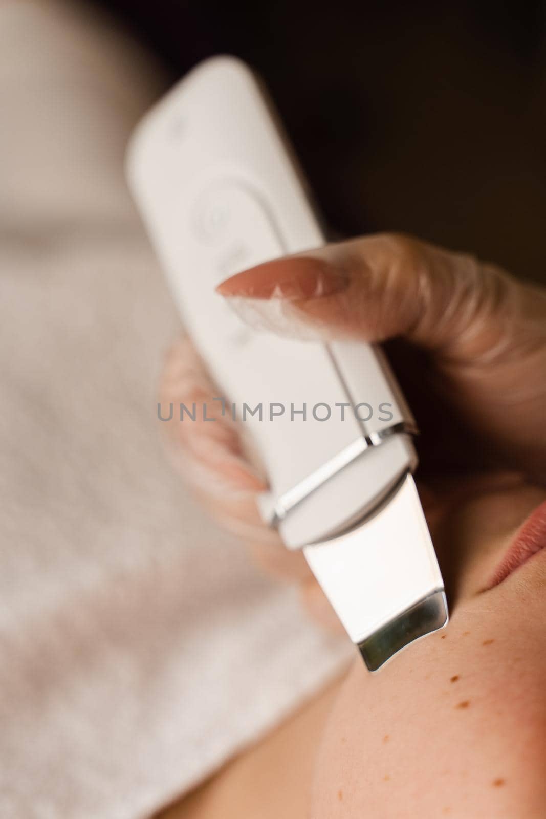 Ultrasonic face peeling close-up. Cosmetology procedure of cleaning facial zone