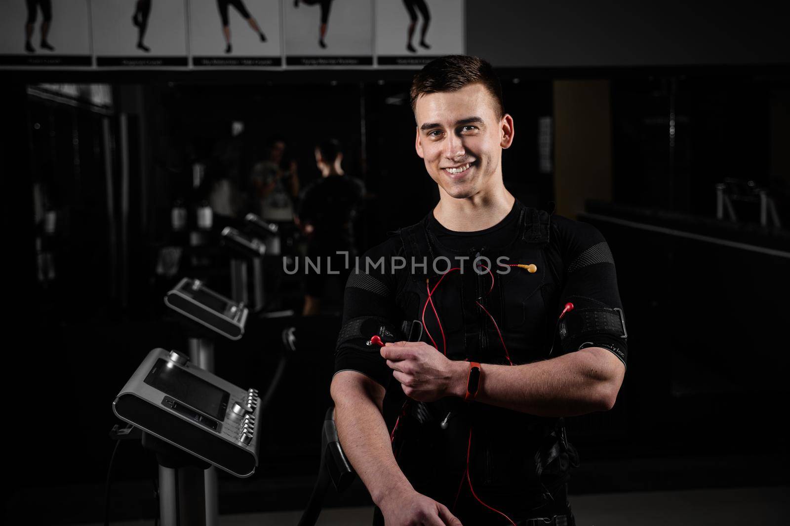 Man with electronic contactor of EMS suit in gym. Sport training in electrical muscle stimulation suit