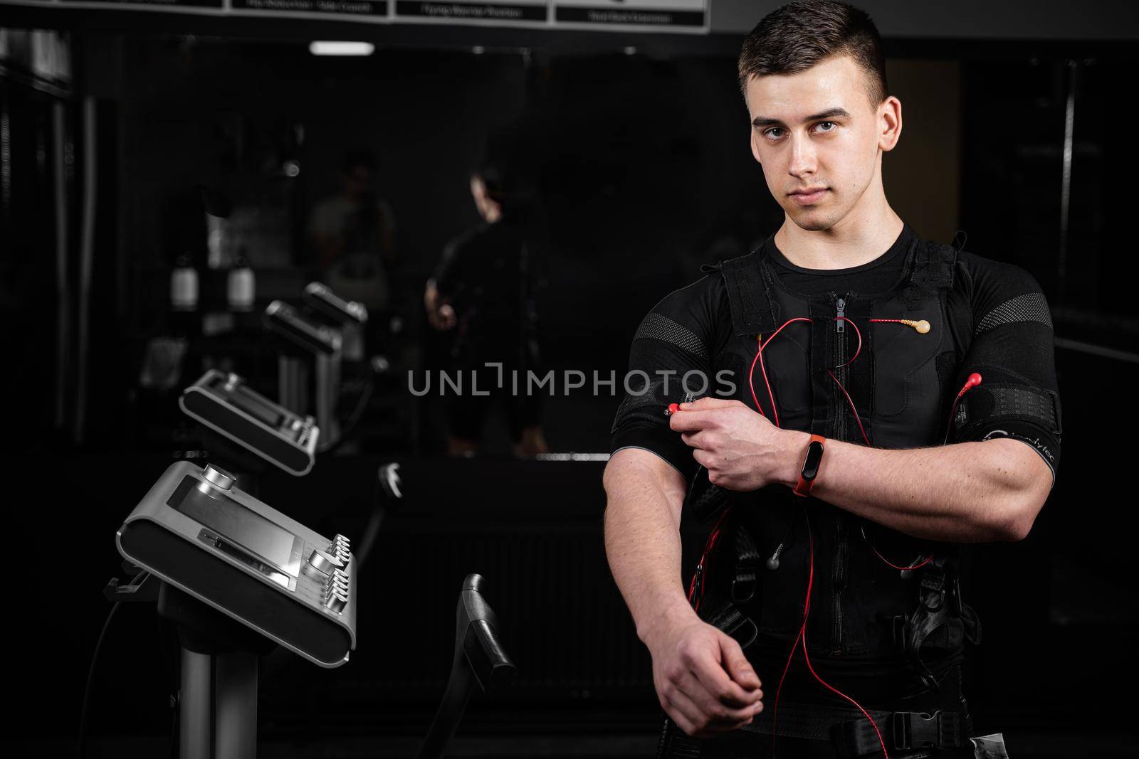 EMS suit with red wires for electro impulse stimulation for body. Training in GYM. by Rabizo