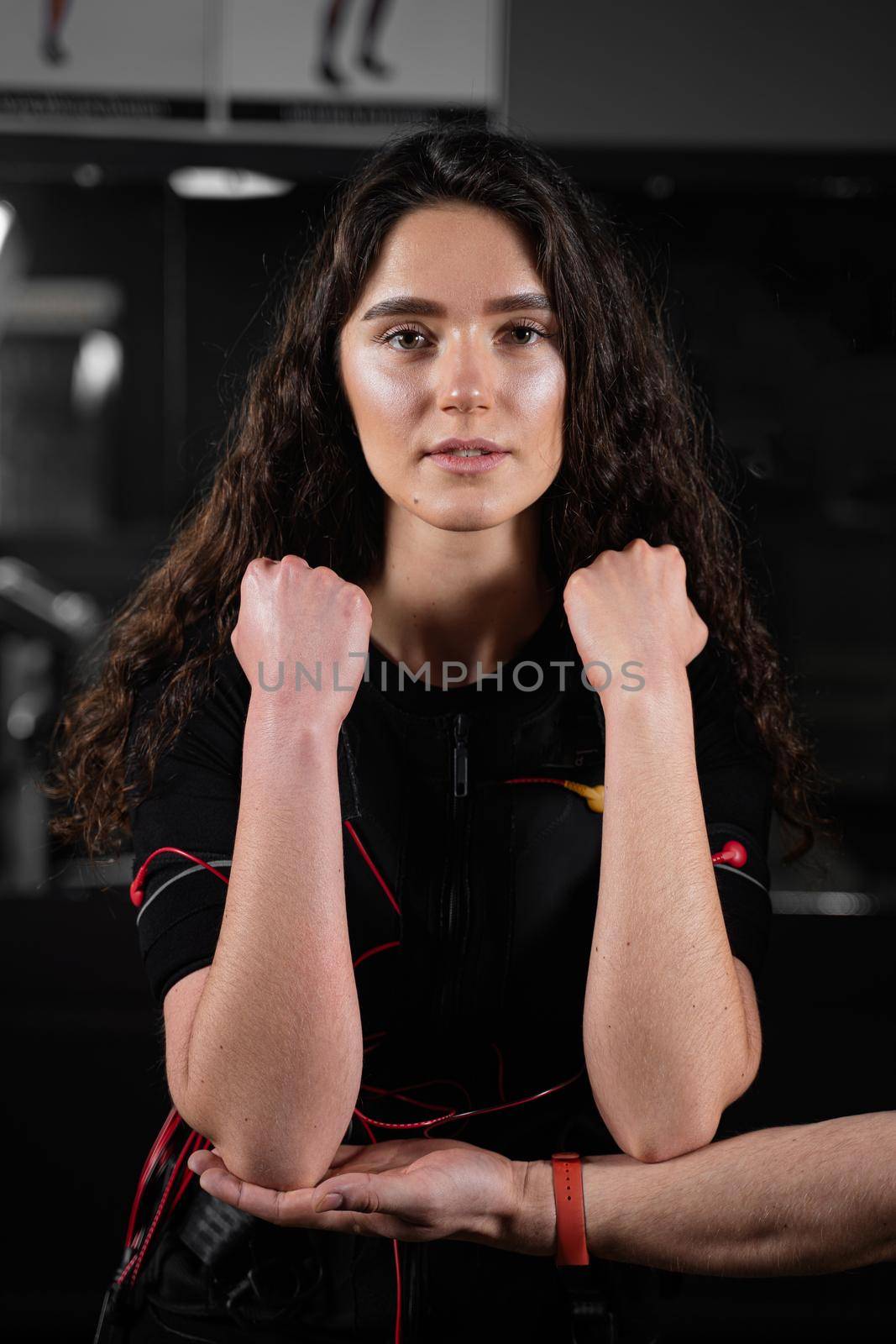 Girl in EMS suit in gym. Sport training in electrical muscle stimulation suit. by Rabizo