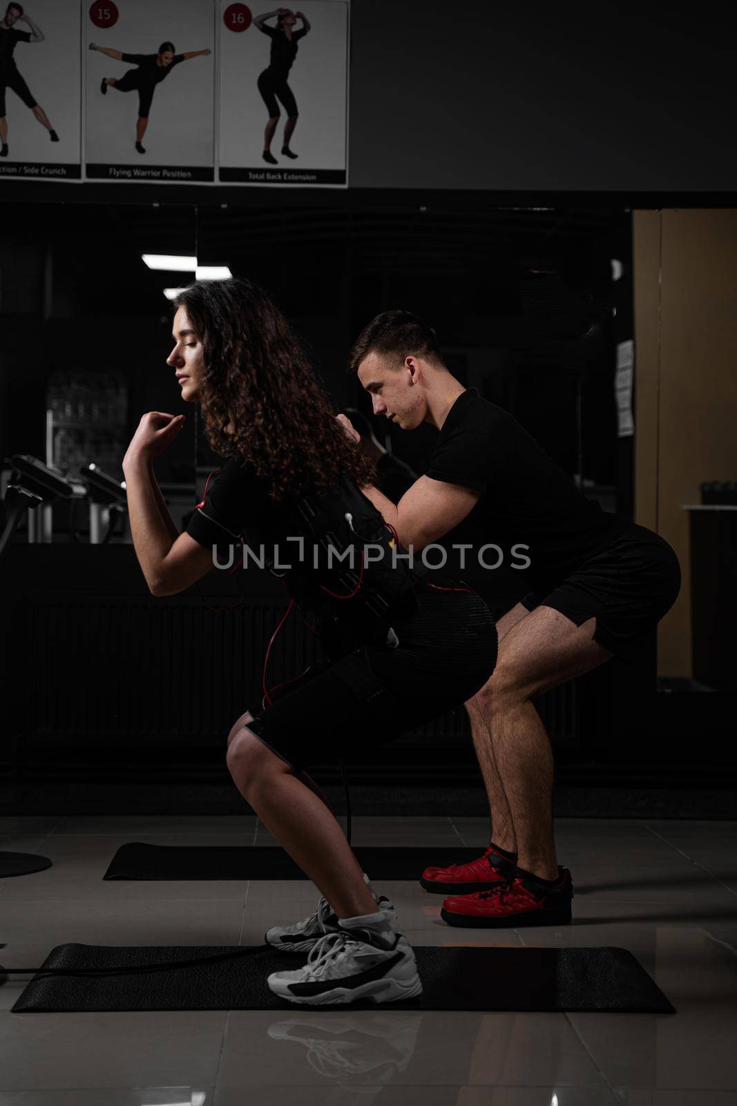 EMS group training for two men and women in the gym. Electrical stimulation for muscles of body