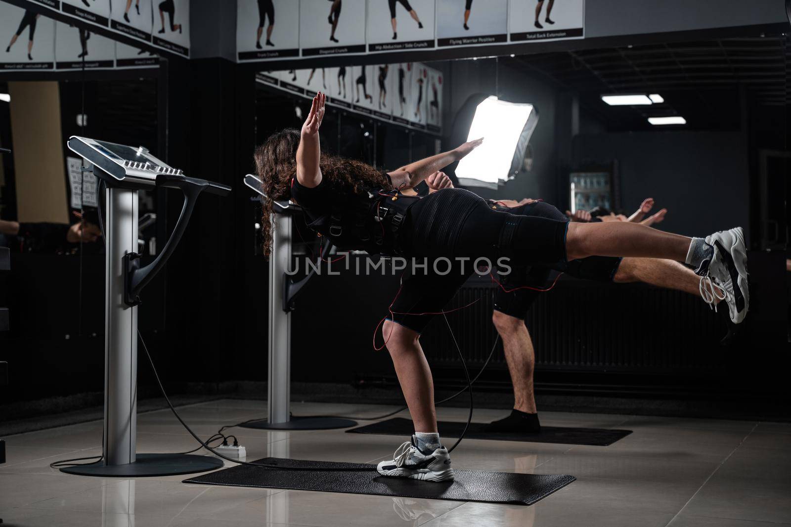 EMS group training for two men and women in the gym. Electrical stimulation for muscles of body. by Rabizo