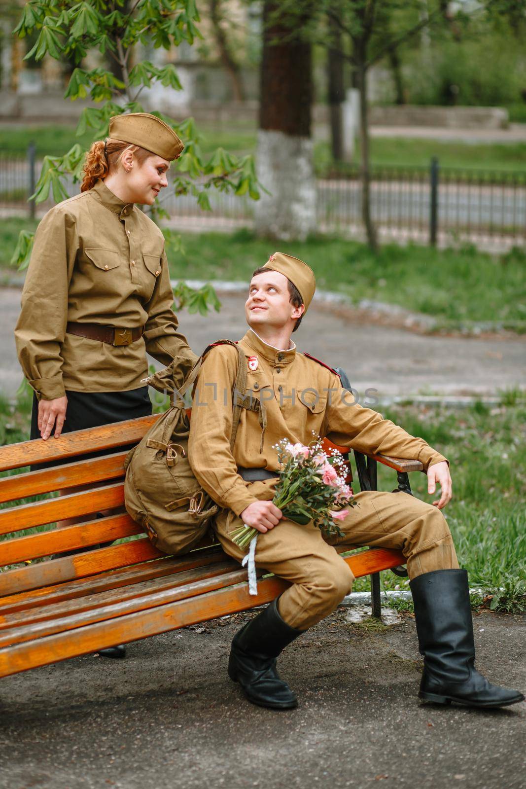 Portrait of two military lovers at a wooden bench