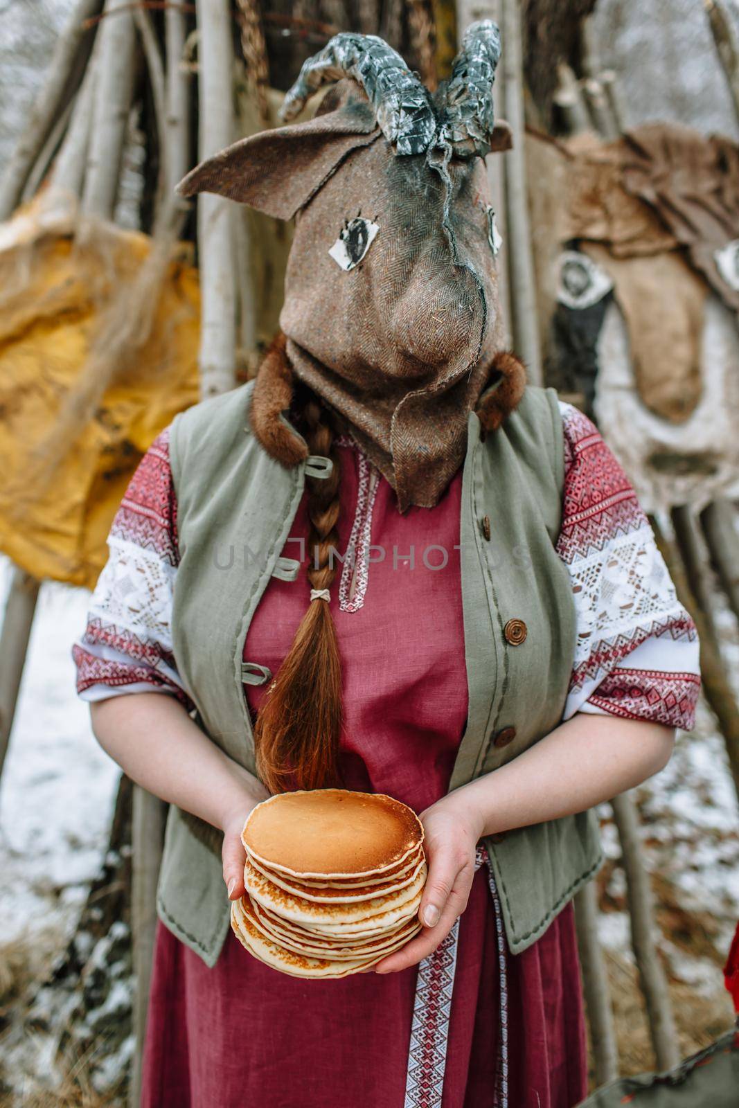 A man in a national costume with the head of an animal celebrates the arrival of the pagan holiday Maslenitsa. An ancient pagan rite by deandy