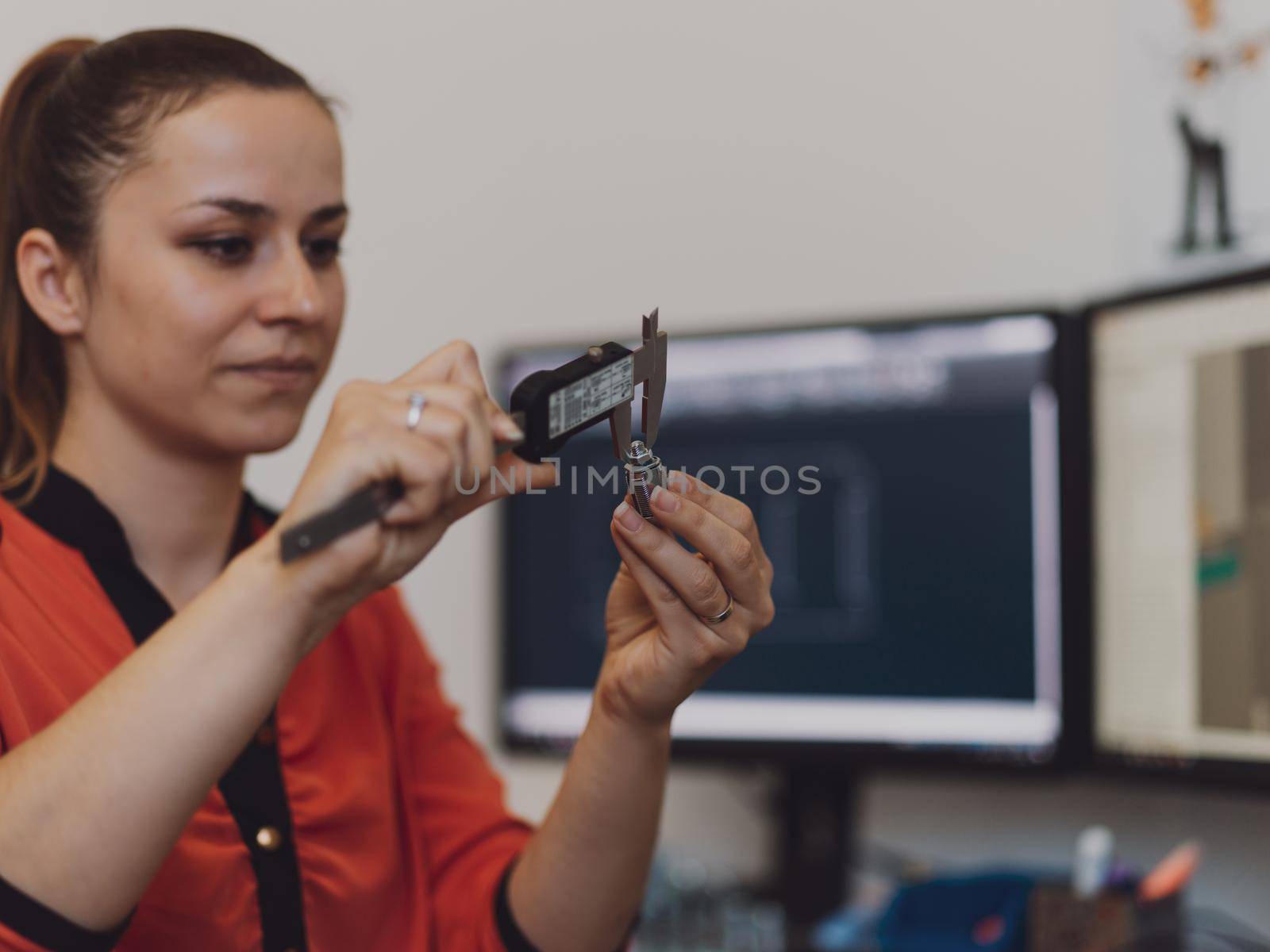 Within the heavy industry, a factory industrial engineer measures with a caliper and on a personal computer Designs a 3D model. High quality photo