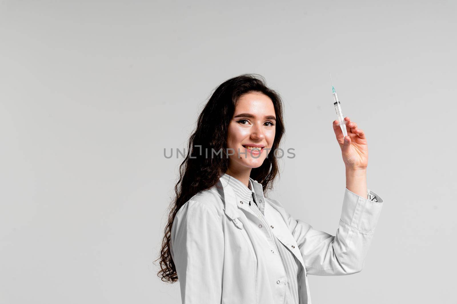 Doctor holding syringe with coronavirus vaccine. Covid-19 Vaccination. Stop quarantine. Attractive girl in medical gloves with syringe and medication