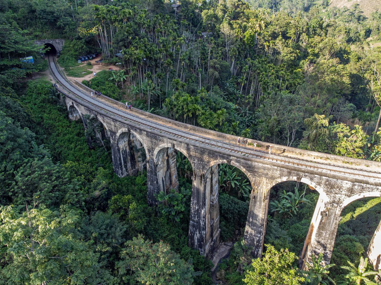 Sri Lanka. The attraction is the ancient railway Nine-arch Demodara Bridge in the midst of a dense tropical forest. Shooting from the air on a drone. Sunny day, sunset.