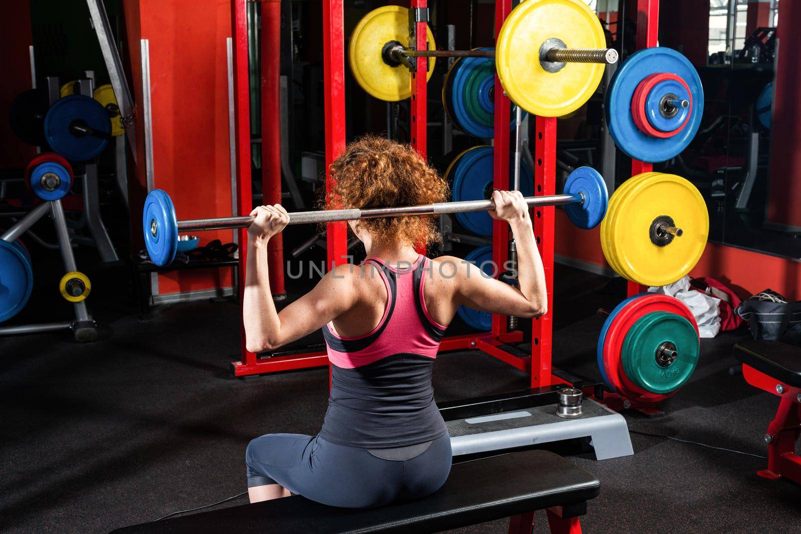 Woman bodybuilder engaged with a barbell in the gym. Healthy lifestyle.