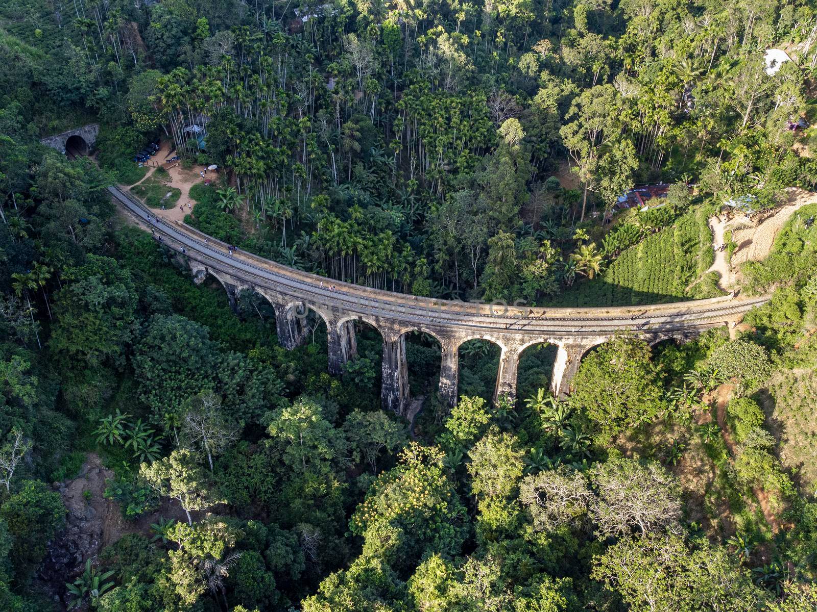 Sri Lanka. The attraction is the ancient railway Nine-arch Demodara Bridge in the midst of a dense tropical forest. Shooting from the air on a drone. Sunny day, sunset.