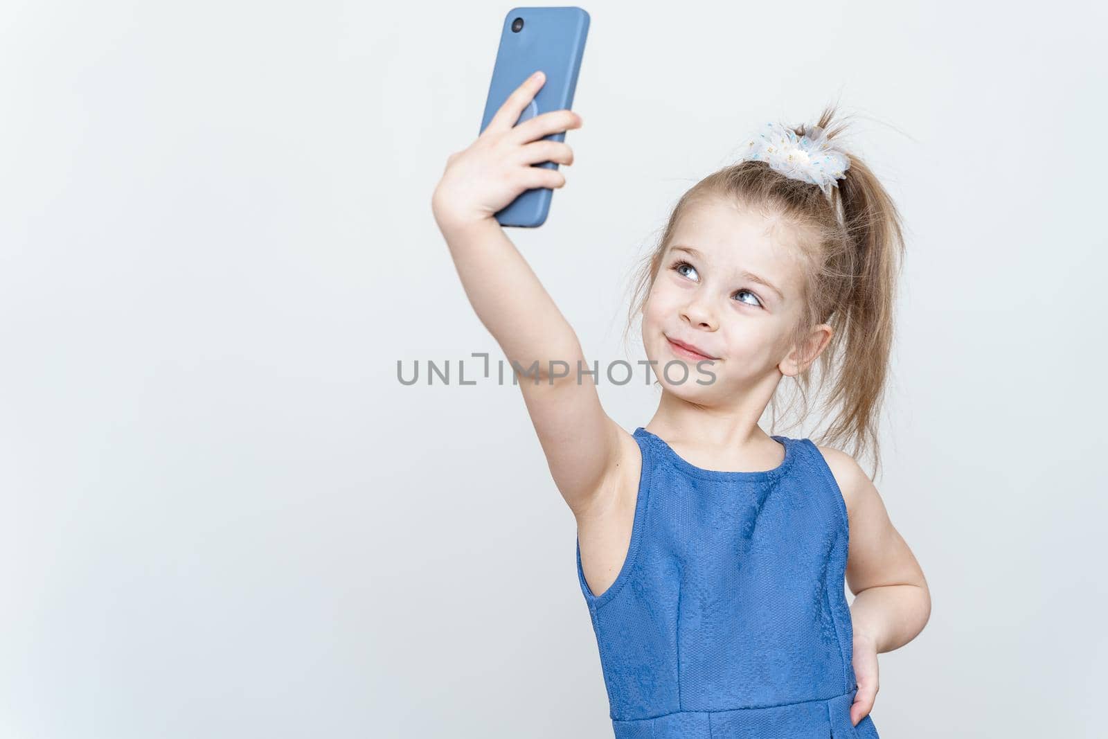 portrait of a cute 5 year old girl with a smartphone by Lena_Ogurtsova