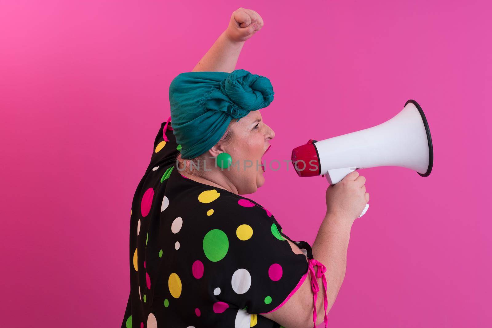 Funny plus size woman woman girl posing isolated on pastel pink wall background studio portrait. People sincere emotions lifestyle concept. Mock up copy space. Screaming in megaphone. High quality photo