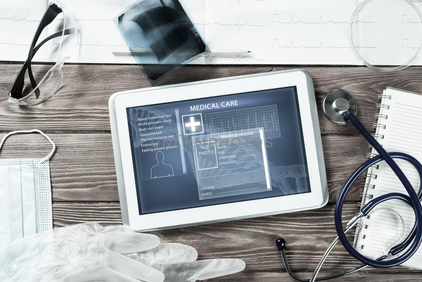 White tablet pc and doctor tools on wooden table