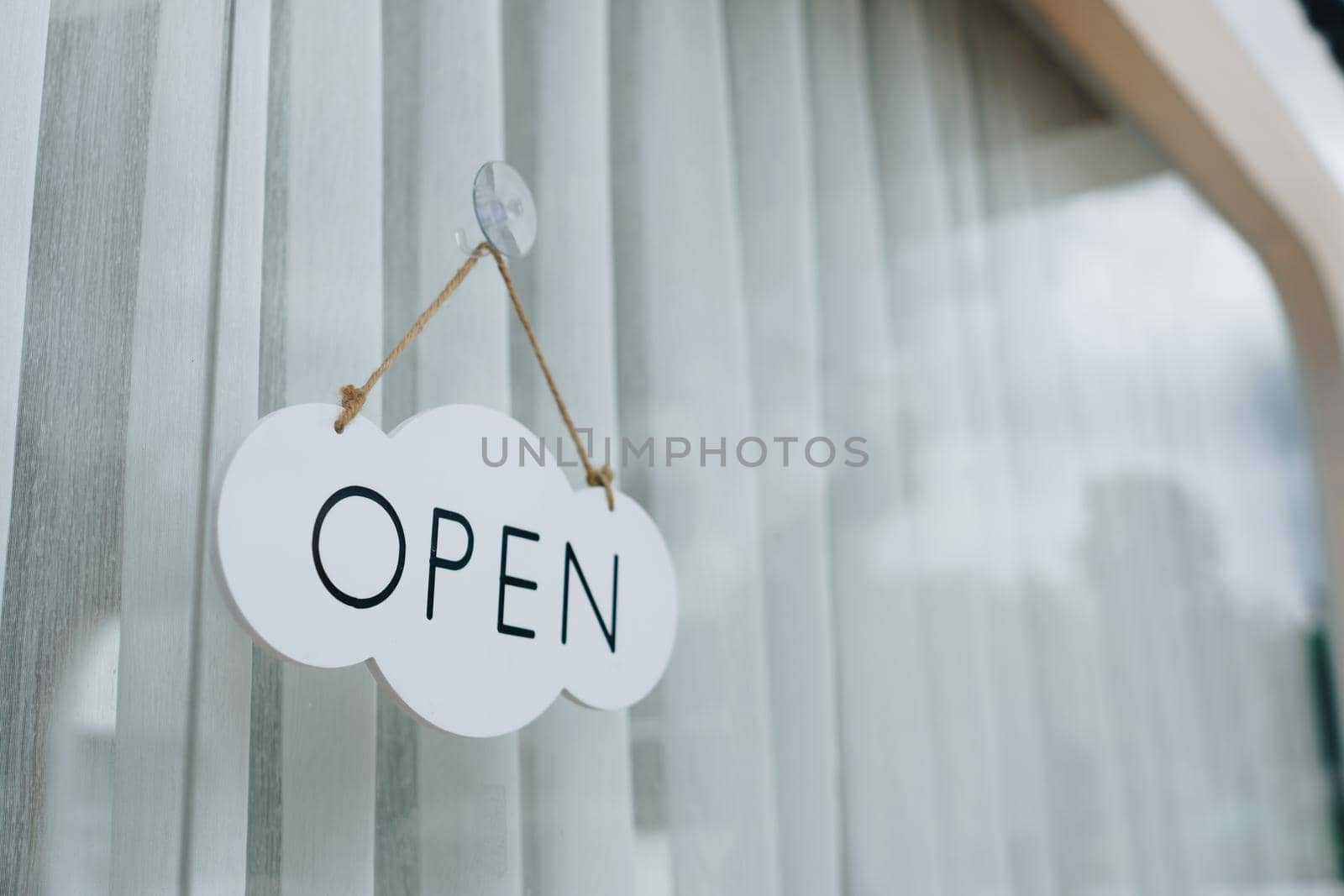 A business sign that says Open on cafe or restaurant hang on door at entrance.  by Suwant