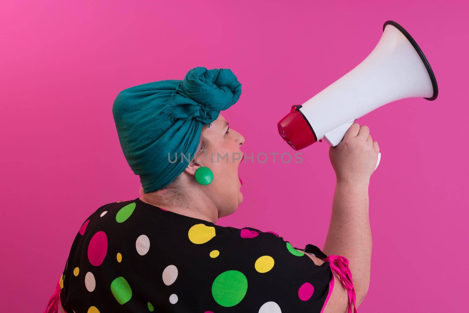 Funny plus size woman woman girl posing isolated on pastel pink wall background studio portrait. People sincere emotions lifestyle concept. Mock up copy space. Screaming in megaphone. High quality photo