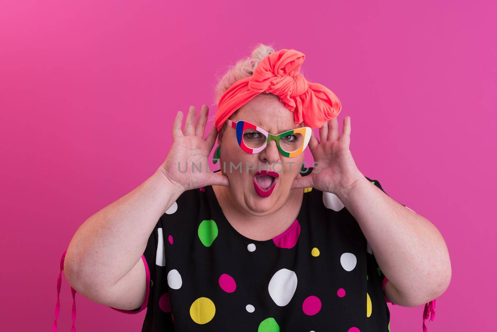 Happy Plus Size Woman Wearing Eyeglasses Smiling To Camera Standing Over Pink Background. Cheerful Millennial Female In Eyewear Posing In Studio. High quality photo