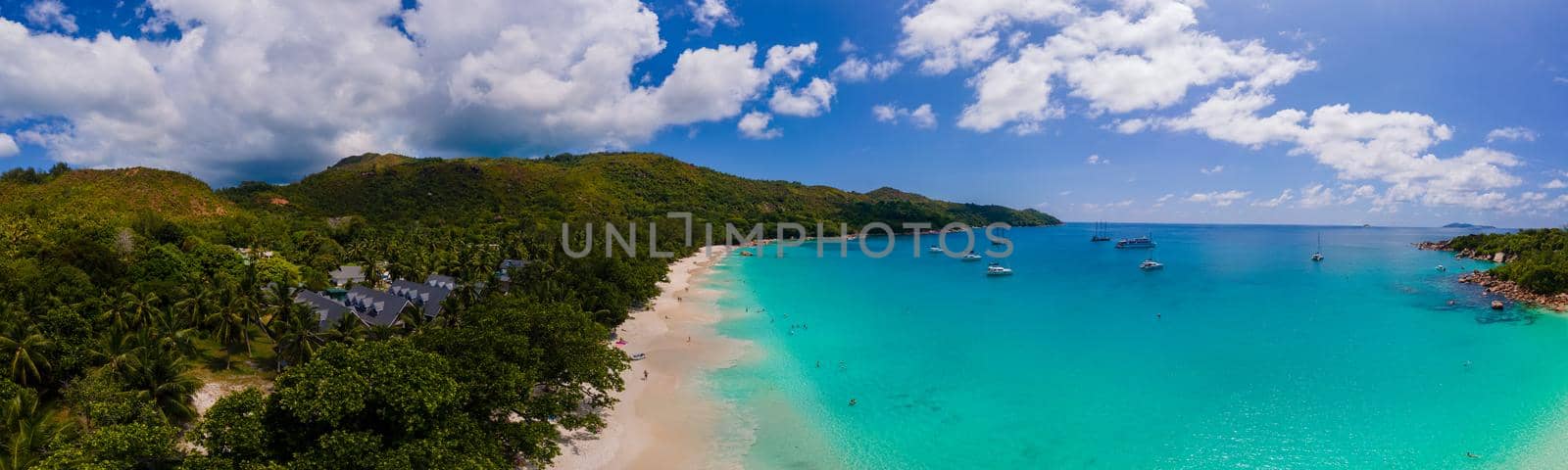Praslin Seychelles tropical island with withe beaches and palm trees, Anse Lazio beach ,Palm tree stands over deserted tropical island dream beach in Anse Lazio, Seychelles by fokkebok