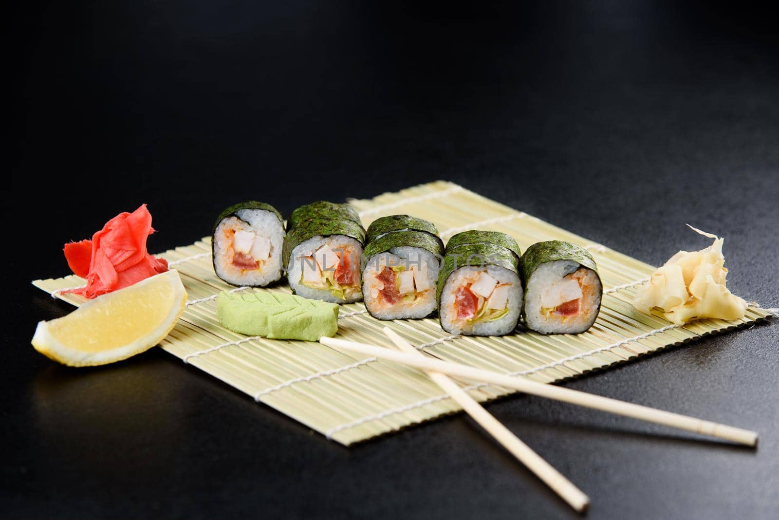 Sushi roll sea food on black background. Sushi delivery from the restaurant. Fresh delicious Japanese sushi with avocado, cucumber, shrimp and caviar on dark background. by Rabizo