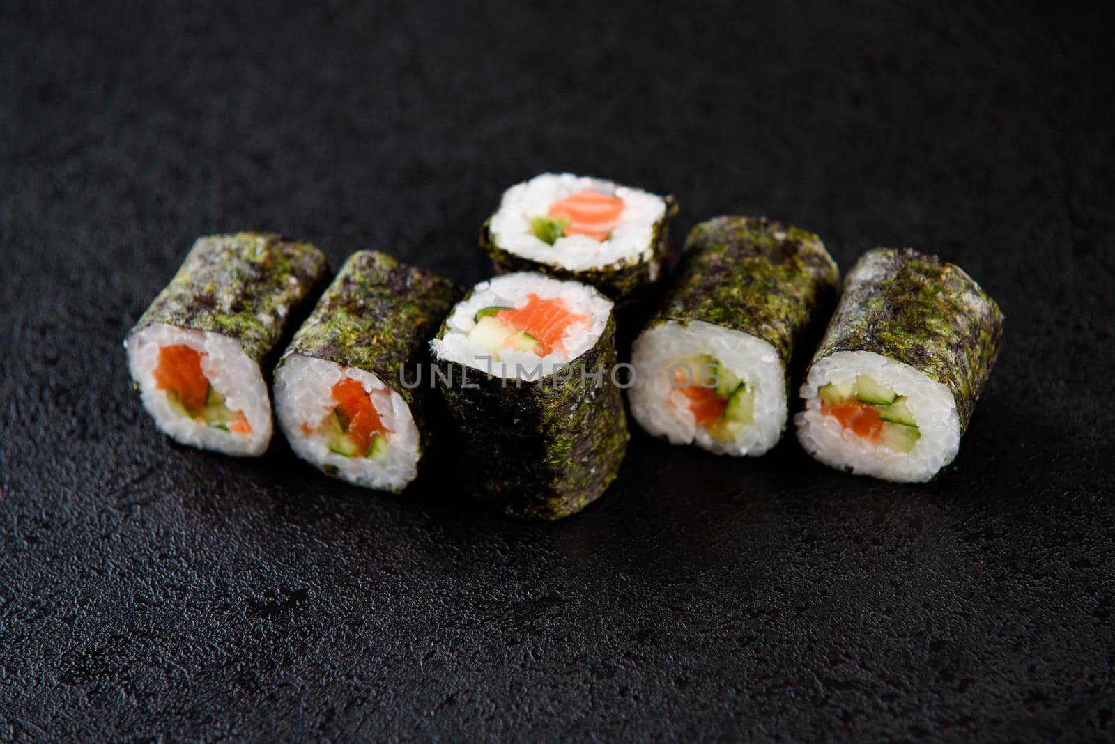 Sushi roll sea food on black background. Sushi delivery from the restaurant. Fresh delicious Japanese sushi with avocado, cucumber, shrimp and caviar on dark background. by Rabizo