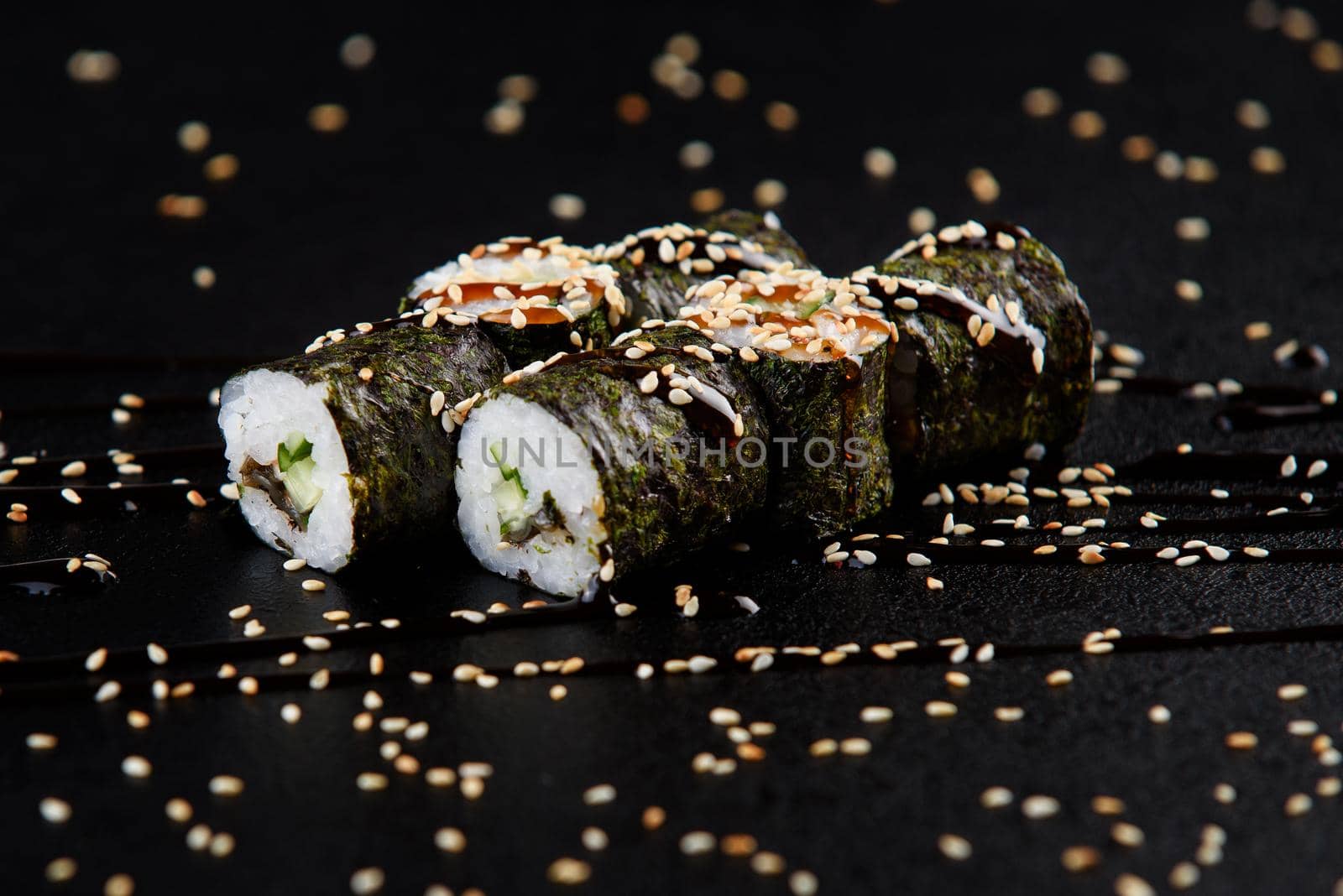 Sushi roll sea food on black background. Sushi delivery from the restaurant. Fresh delicious Japanese sushi with avocado, cucumber, shrimp and caviar on dark background. by Rabizo