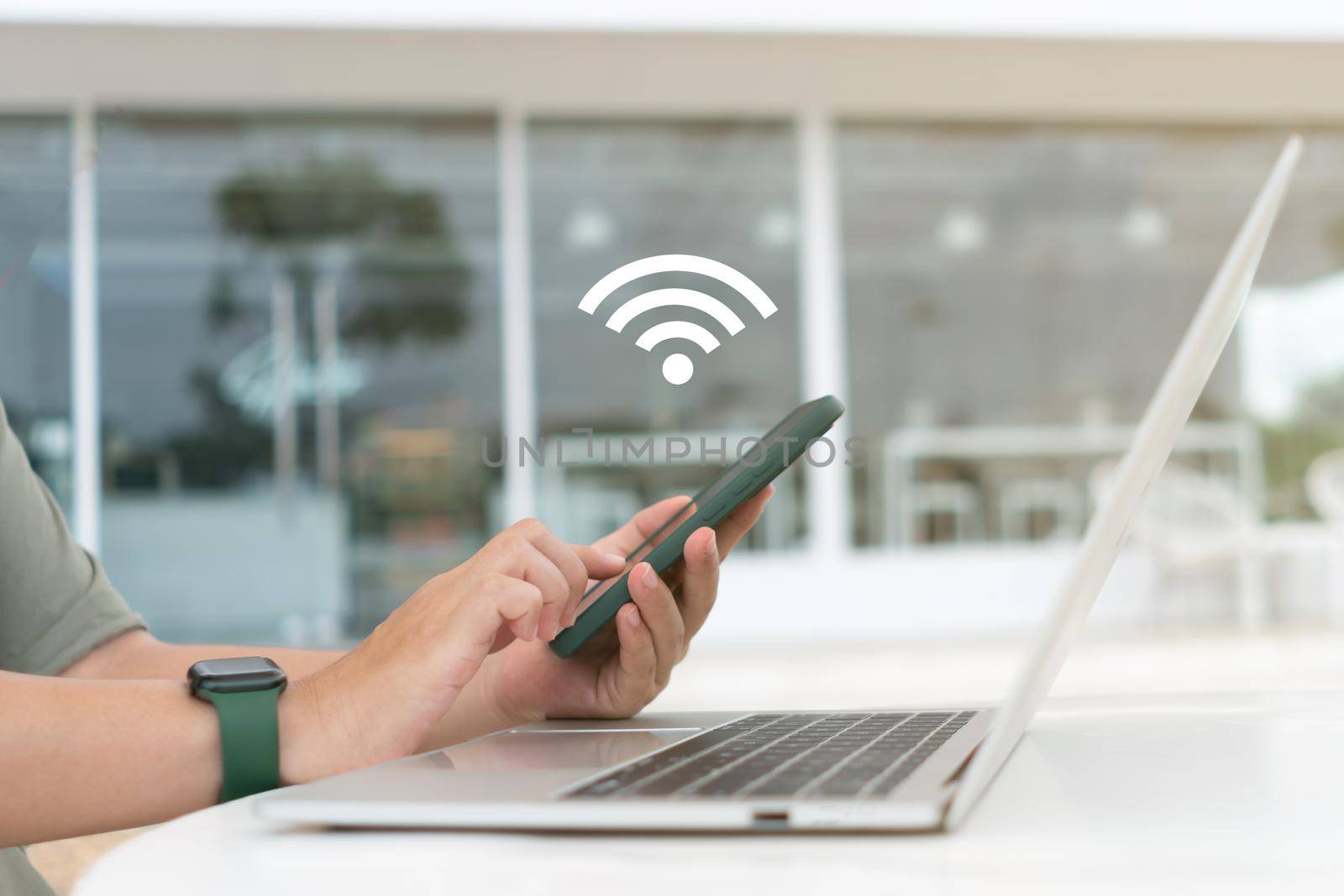 In a cafe shop background, a woman uses a laptop with a wifi icon. Social networking concept. by Suwant