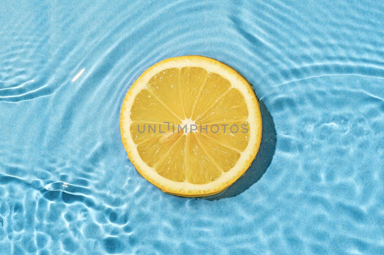 Circle texture fruit summer lemon in bright pool with wave movement fresh water.