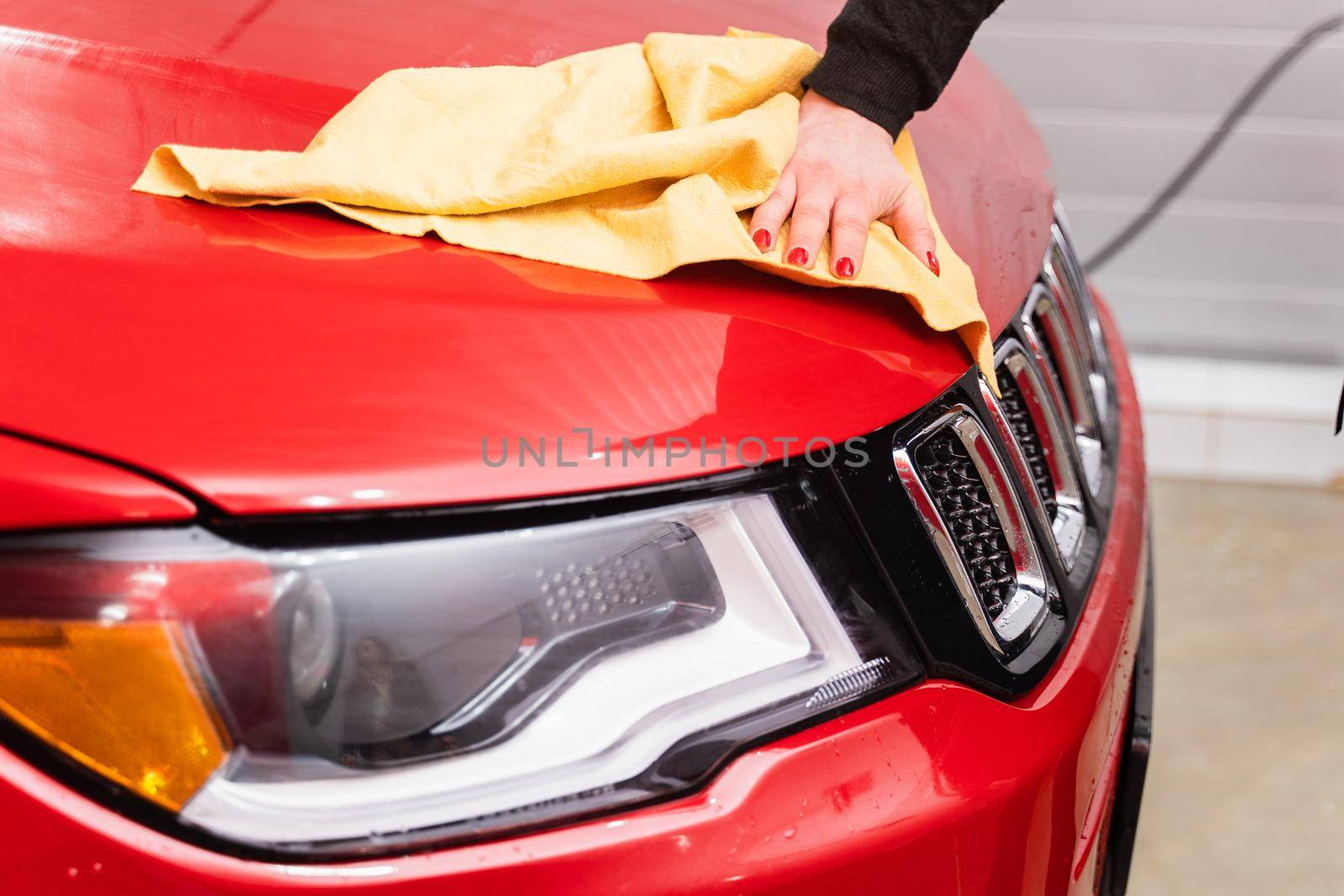 Car polishing with yellow microfiber cloth. Protection of paintwork.