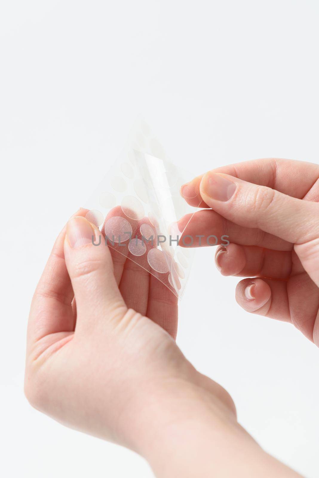 Round patches for acne and wrinkles on the hands on a white background. Acne and wrinkle patches for facial rejuvenation. Facial cleansing cosmetology.