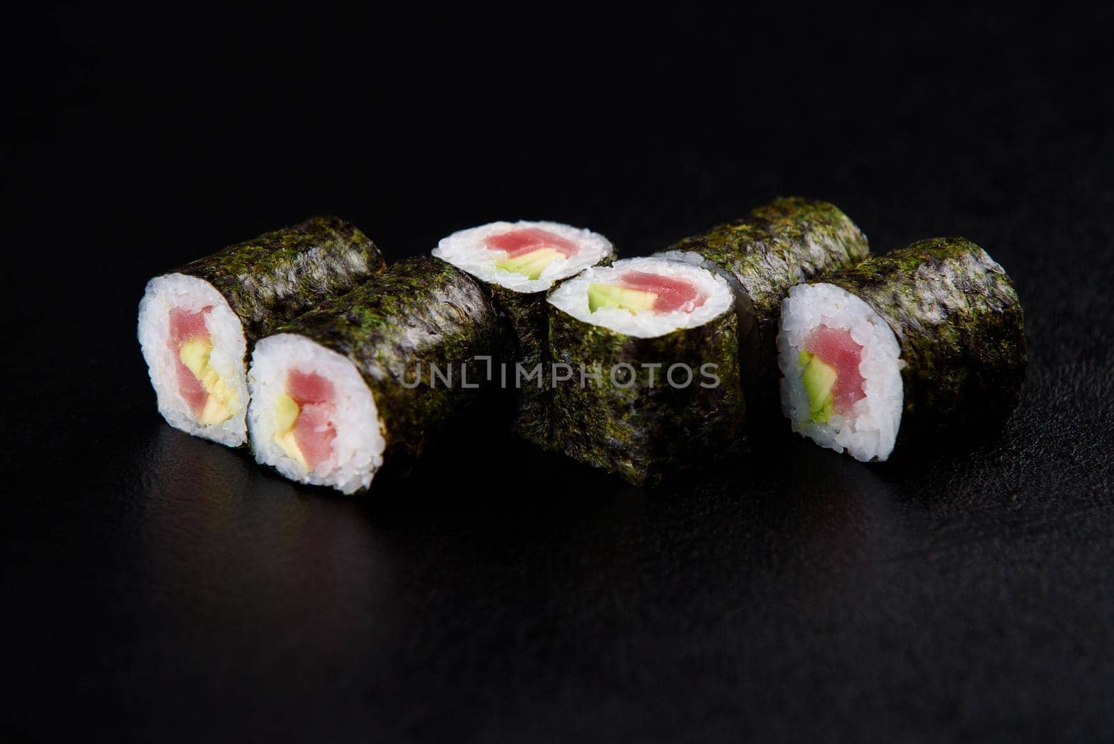 Sushi roll sea food on black background. Sushi delivery from the restaurant. Fresh delicious Japanese sushi with avocado, cucumber, shrimp and caviar on dark background. by Rabizo
