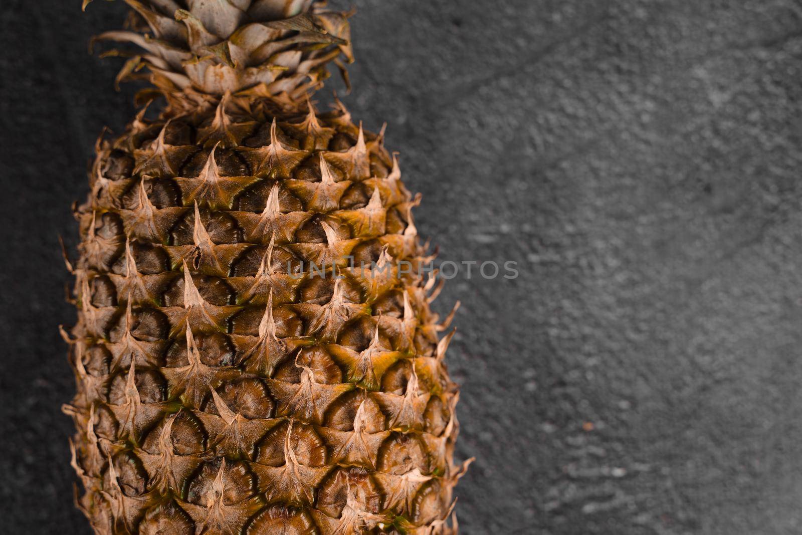 Pineapple tropical fruit on dark stone background background. Citrus fruit with vitamin c for helth care. by Rabizo