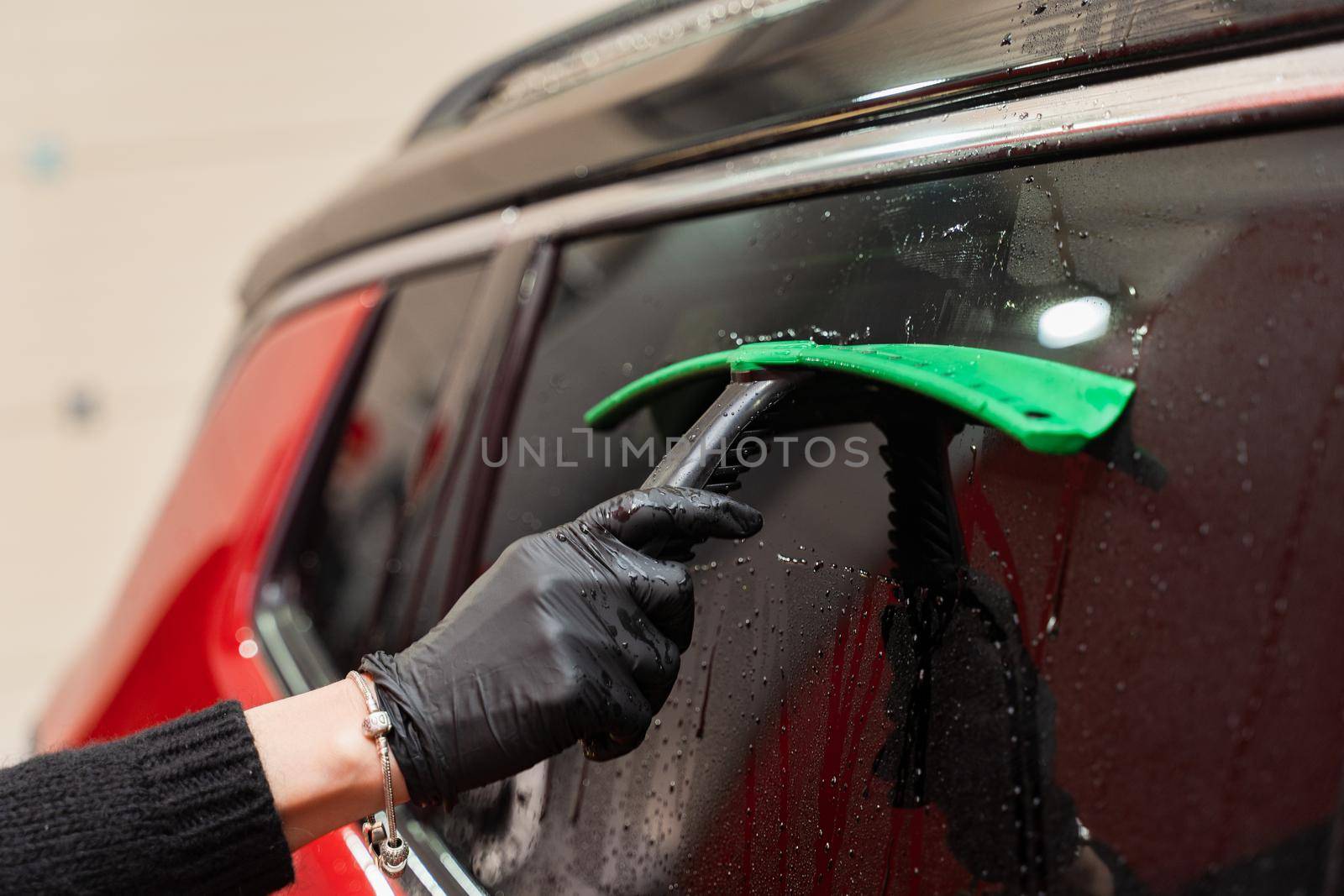 Removal of residual water from the glass with a rubber scraper after washing the car. Car Wash. Self-service complex. High-pressure car wash. by Rabizo